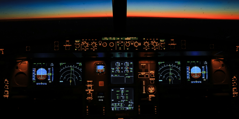 Airplane cockpit at night with sunset view outside